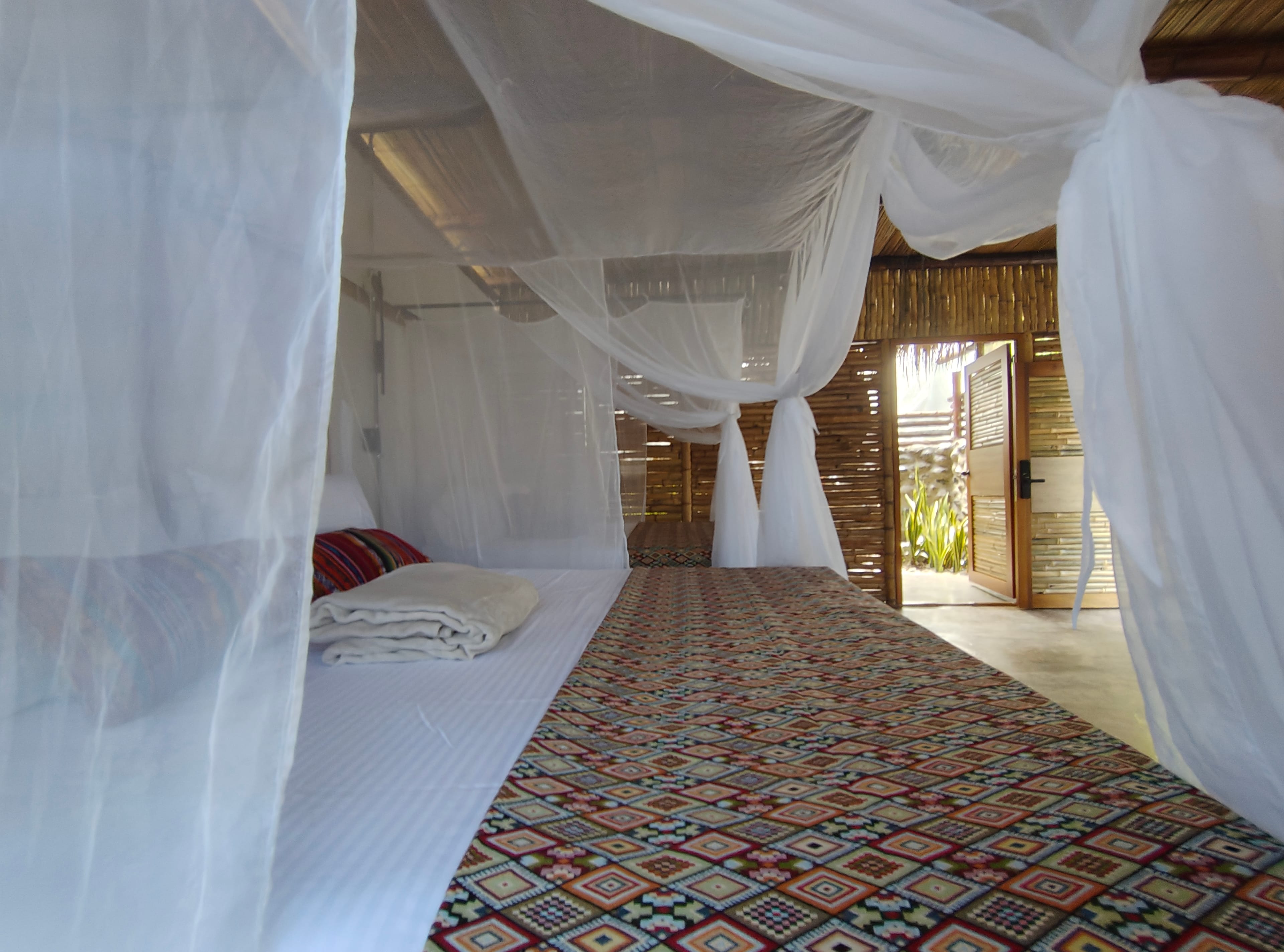 Interior de Suite Familiar con dos camas dobles con mosquitero y textiles artesanales