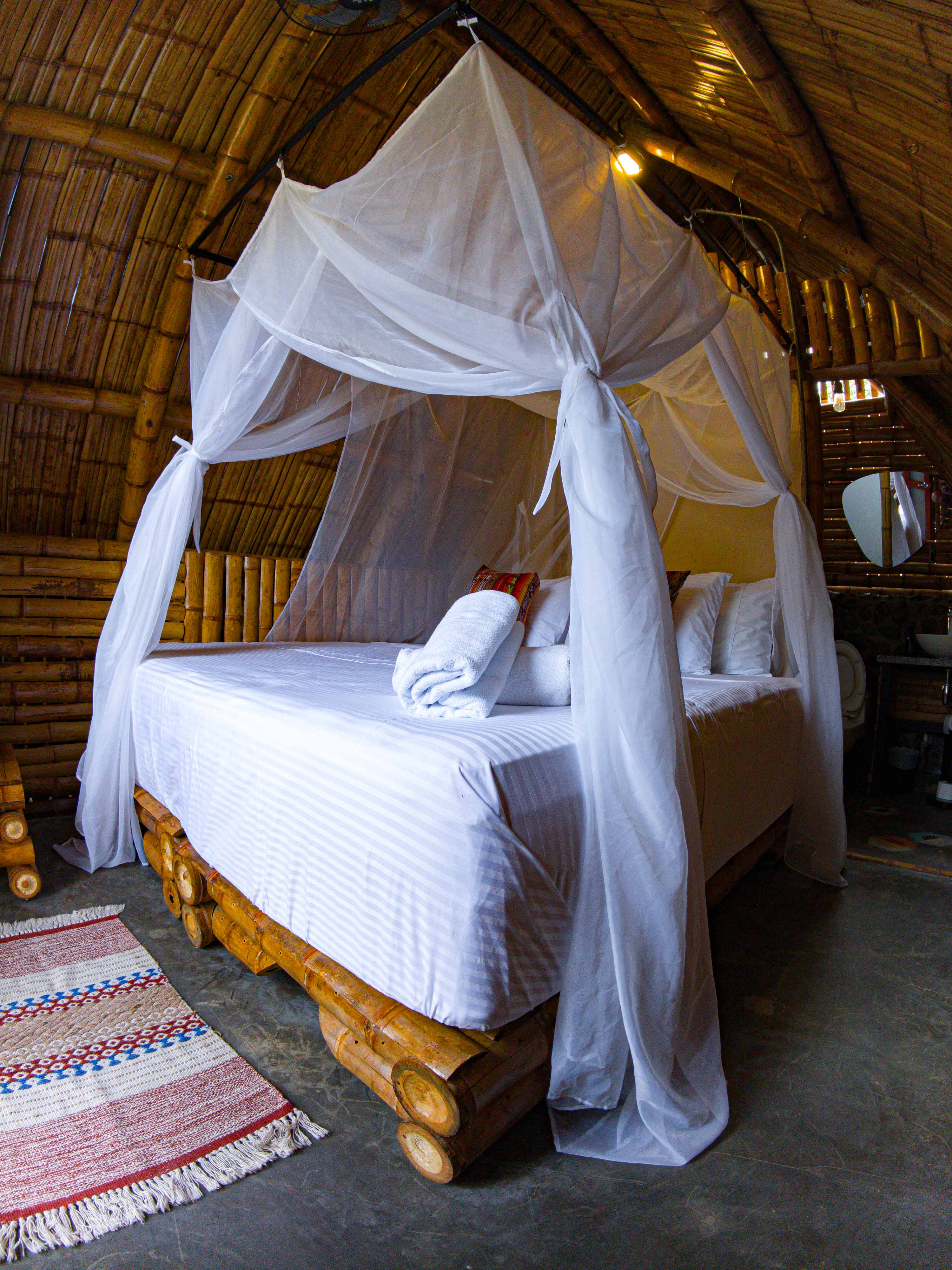 Cama con mosquitero y lencería de lujo en refugio Sol del Desierto