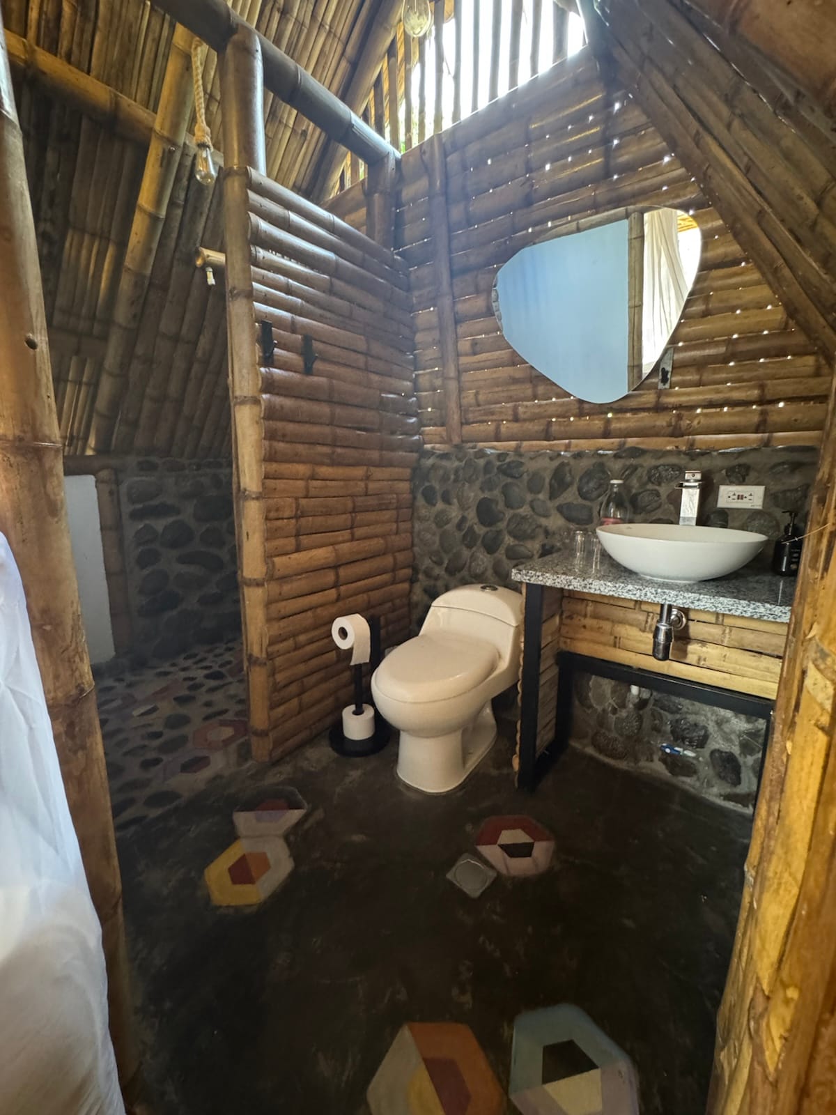 Baño privado con construcción de bambú y piedra